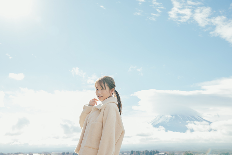 秋元真夏　卒業記念写真集『タイトル未定』(幻冬舎)より背後には山頂付近が雲で隠れてしまった富士山が