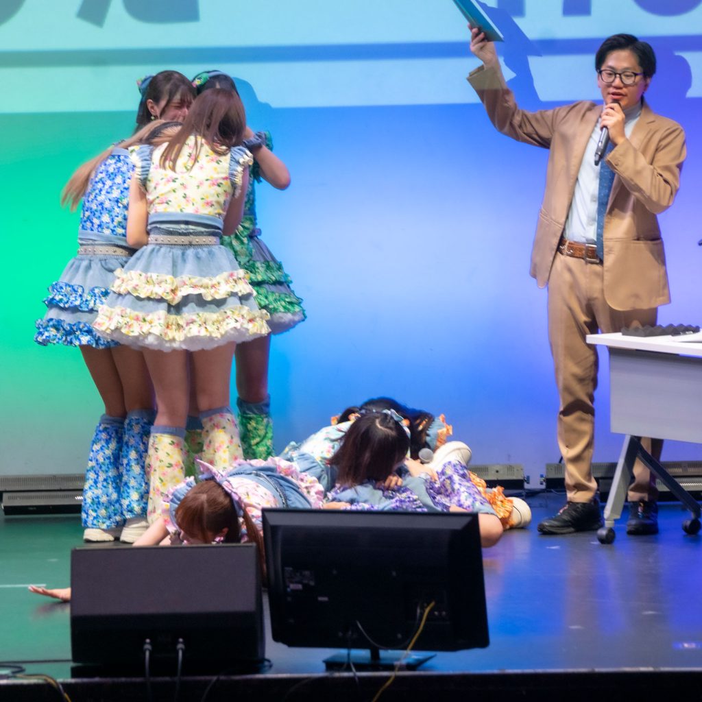 悲願の優勝にステージに崩れるメンバーと抱き合うメンバー