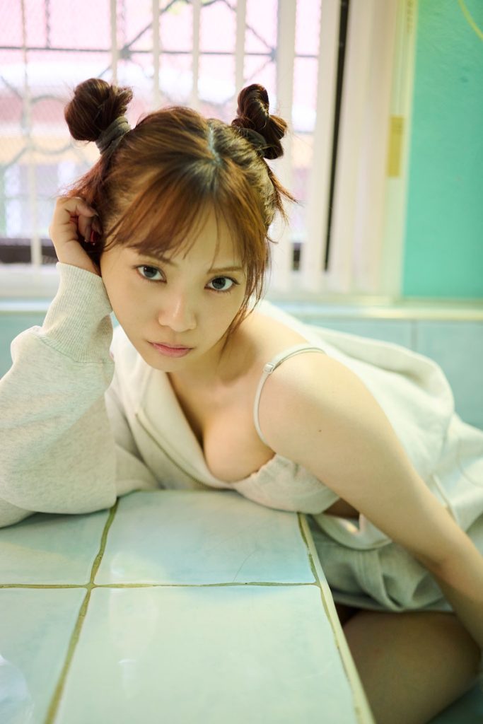 『宮田愛萌1st写真集』(幻冬舎)より、現地のおうちを借りて撮影したカット。パステルカラーのタイルにリラックスムードなスタイリング、おだんごヘアもかわいい1枚