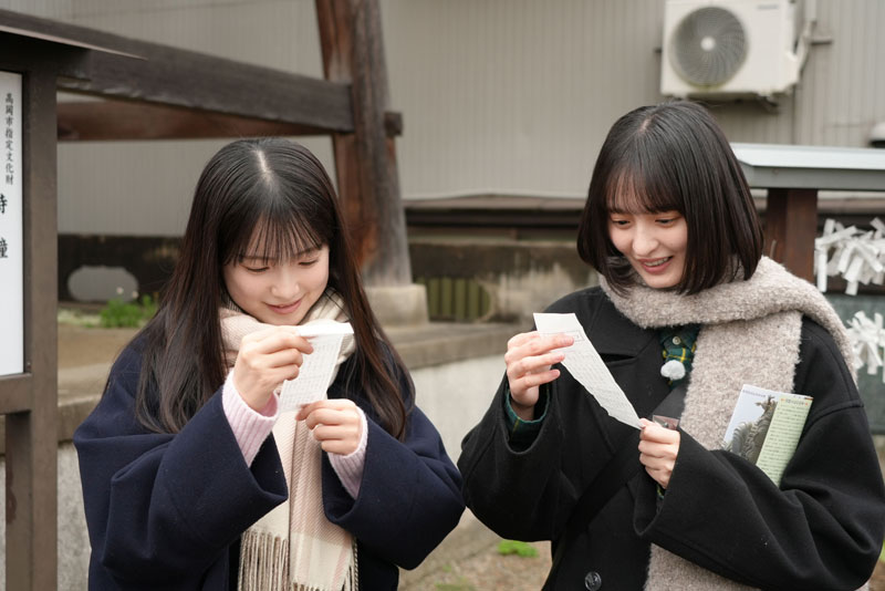 おみくじの結果をじっくりと読み込む遠藤さくらと鈴木佑捺