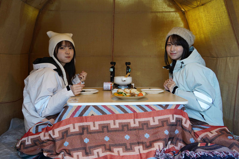 かまくらの中でこたつに入りながらチーズフォンデュを味わう
