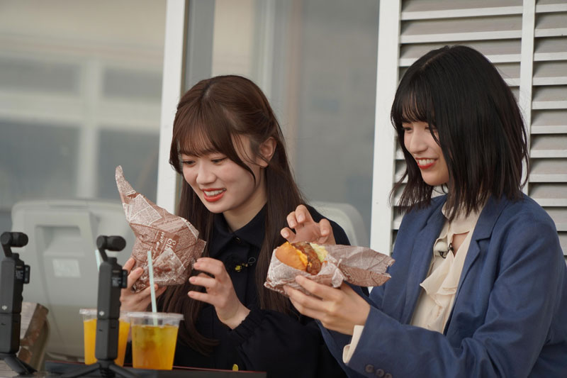 “ミルミルチーズバーガー”を前に笑顔を見せる五百城茉央と愛宕心響