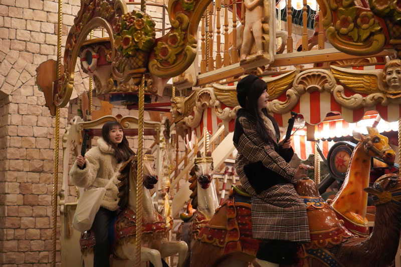 屋内に設置されたメリーゴーランドを楽しむ池田瑛紗と矢田萌華