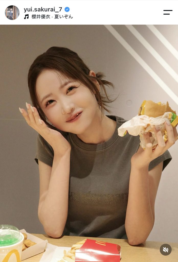 ハンバーガーを手にカメラ目線でニッコリ